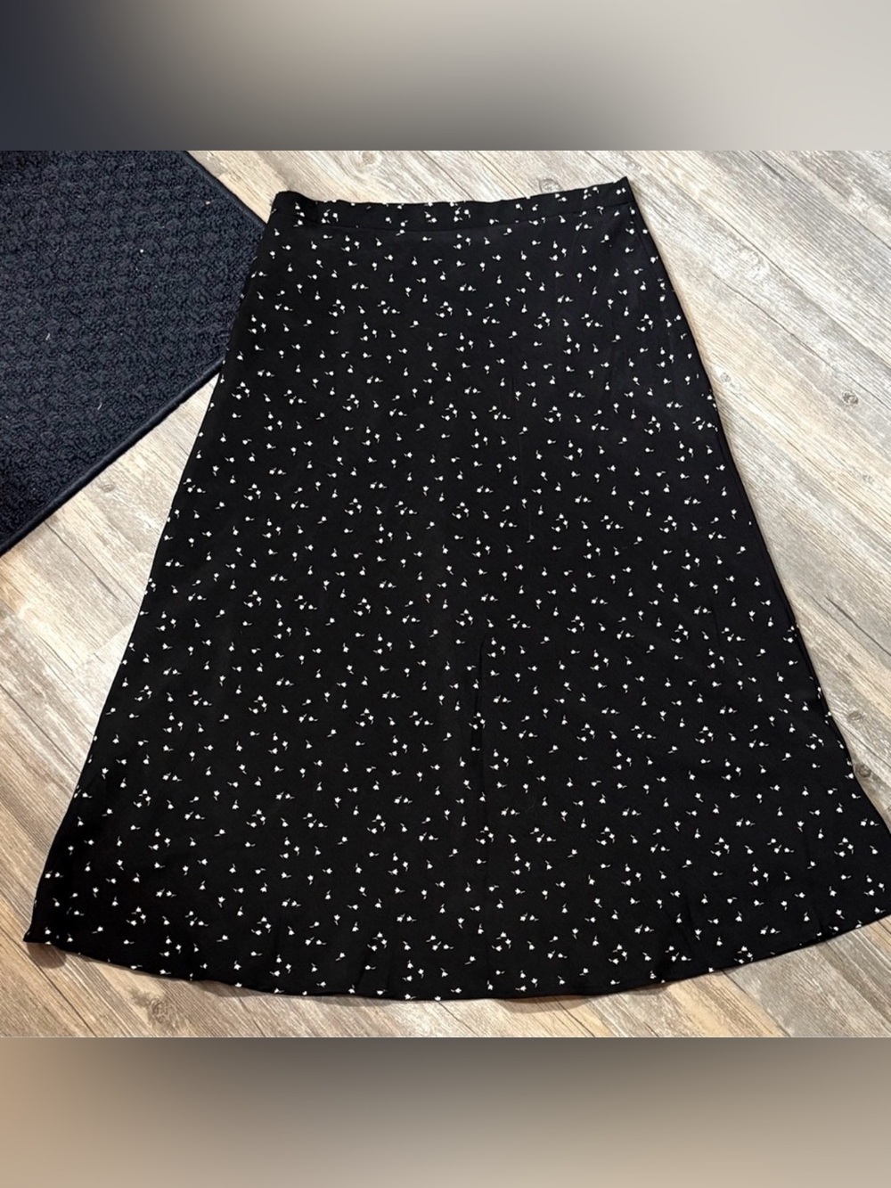Oak + Fort black A-line midi skirt featuring a delicate floral pattern.